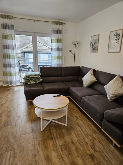 Aufenthaltsraum: Blick auf Sofa mit Beistelltisch, Balkon im Hintergrund